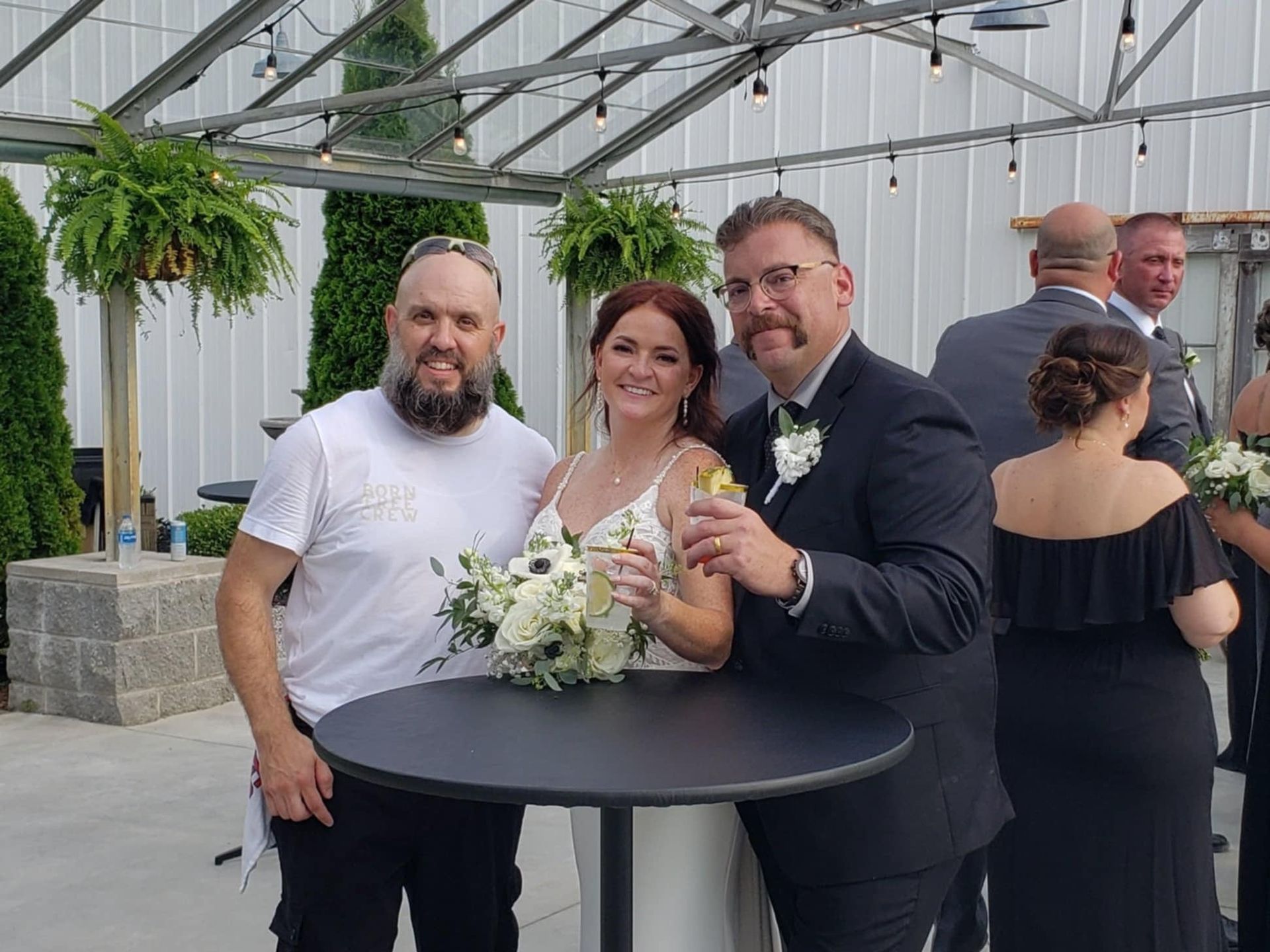 Founder Randy and groom toasting with cocktails outdoors